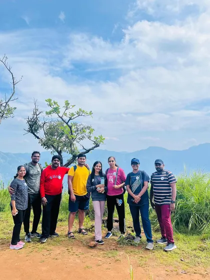A small group from the Netravathi trek posing on the trail with the mountains in the background.