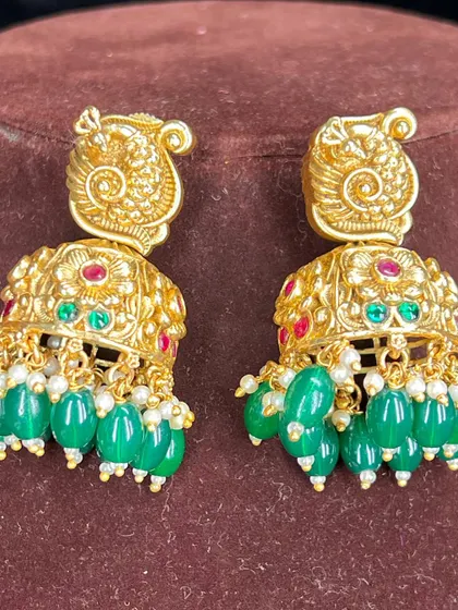 A pair of beautiful temple jhumkas with peacock tops and green bead drops. These are a perfect match for many of my antique gold sets.
