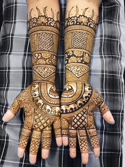 This intricate bridal design features a lovely elephant theme. The patterns are a mix of geometric checks and traditional motifs, creating a balanced and beautiful composition for the bride.