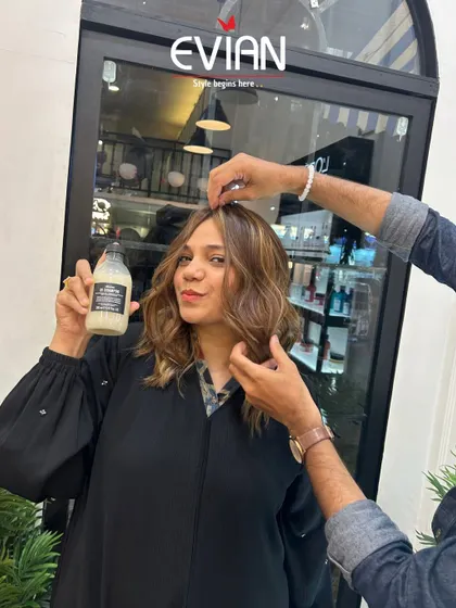 A happy client holding a Davines product after her service. I always recommend the right at-home care to maintain salon-fresh results.
