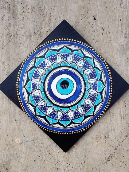 An "Evil Eye" or "Nazar" mandala, designed to ward off negative energy. I used shades of blue and turquoise with gold details to create this protective wall hanging.