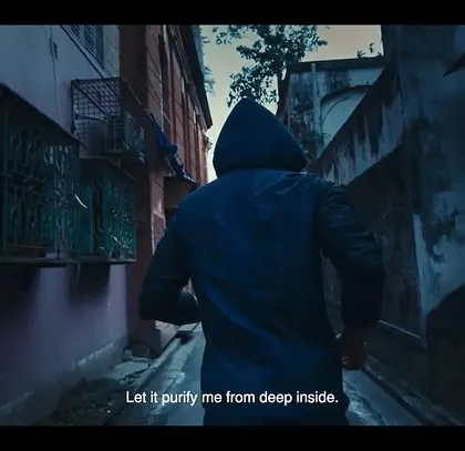 A moody, atmospheric shot from the East Bengal FC ad. The character's dark, hooded jacket creates a sense of mystery and determination as he runs through the streets of Kolkata.