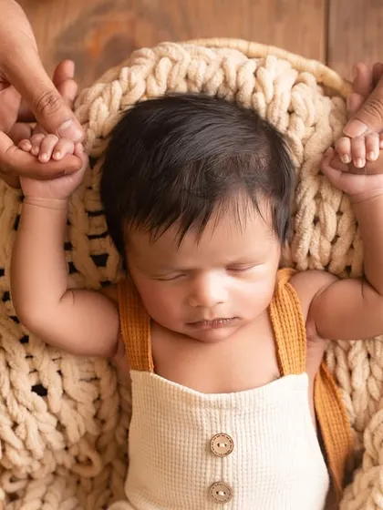 A close-up of a newborn's hands holding onto his parents' fingers. A timeless and emotional detail shot that every parent will cherish.