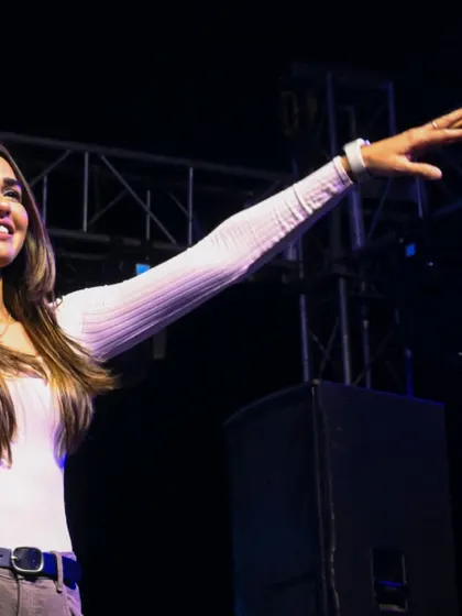 A joyful, high-energy shot of me reaching out to the crowd at the Rangrez 2025 Holi festival. The connection with the audience is everything.