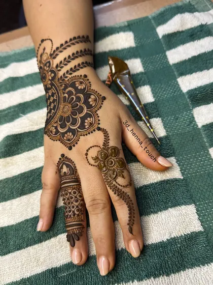 Another view of the graceful floral mandala design, with the henna cone showing the fresh paste used for a dark, beautiful stain.