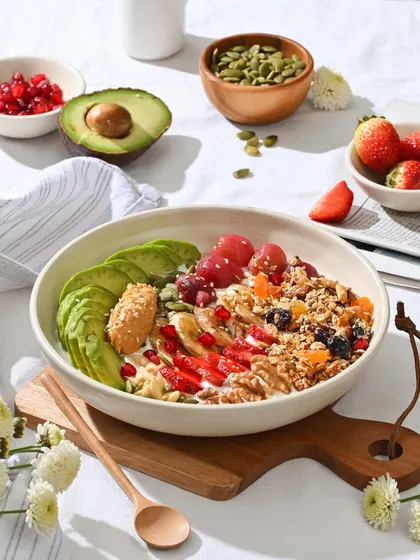 A vibrant and healthy breakfast bowl with granola, fresh fruits like avocado and strawberries, and nuts. The perfect way to start your day.