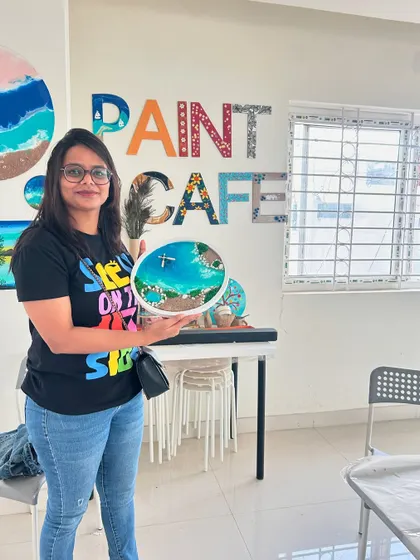 A repeat image of a participant holding her island-themed resin art.