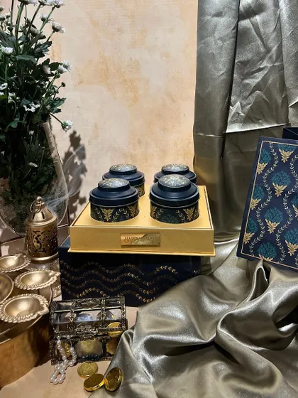 A sophisticated navy and gold themed dry fruit box with a matching bag. The intricate patterns give it a very royal and festive feel.