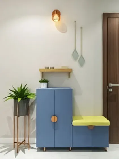 A simple and charming entryway solution with a blue shoe cabinet that includes a small, cushioned seating area.