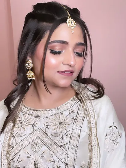 A subtle and glowing party makeup look, perfect for a daytime event. The half-braid hairstyle adds a touch of elegance.