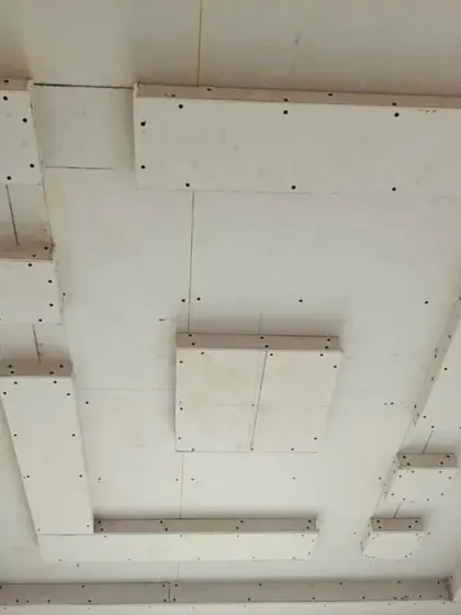 A look at a ceiling design with floating panels before the finishing stage. The visible screws and joints are all covered and smoothed for a flawless final look.
