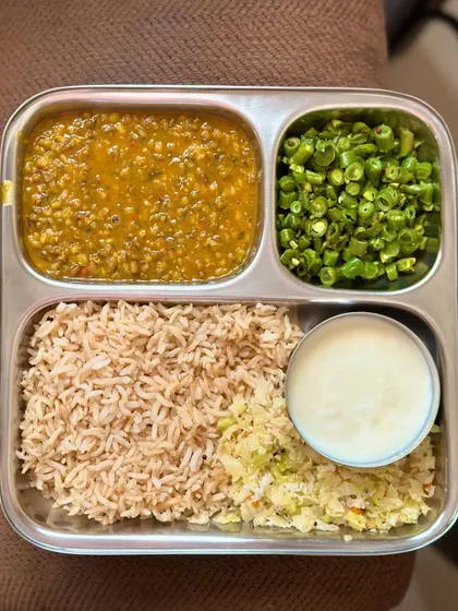 A repeat of the wholesome plate of brown rice, whole green gram dal, sautéed beans, and cabbage, with a side of curd.