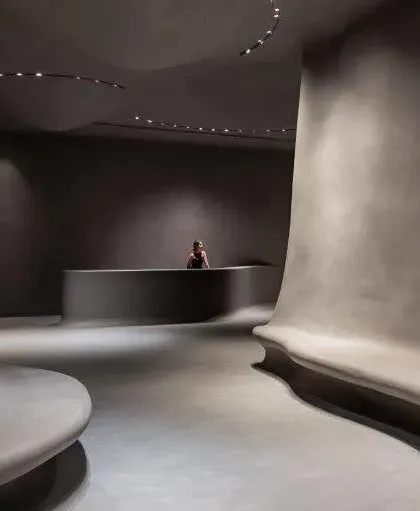 The minimalist reception area of the Aatma Manthan Museum. The curved desk and flowing walls continue the organic design language, setting a tone of introspection from the moment of entry.