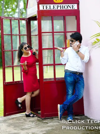 A fun, interactive shot with a couple pretending to talk on phones from inside and outside a red telephone booth.