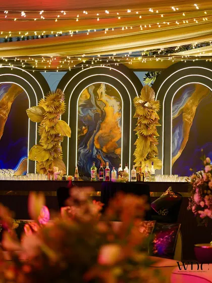 A bar counter so chic, you can't hide your drinks. The bar for the 'Twilight Affair' featured a stunning blue and gold abstract art backdrop and modern gold floral installations.