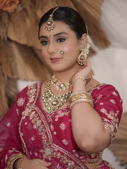 A complete bridal look featuring a heavy, gold-plated Kundan necklace, haath phool, and maang tikka, all available for rent.