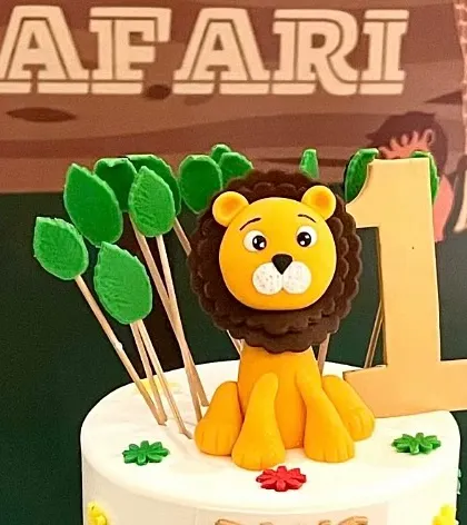 A close-up of the adorable lion cake topper from the jungle safari party.