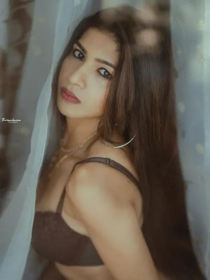 This intimate portrait, shot through a sheer curtain, has a soft and mysterious feel. The direct gaze of the model creates a powerful connection.