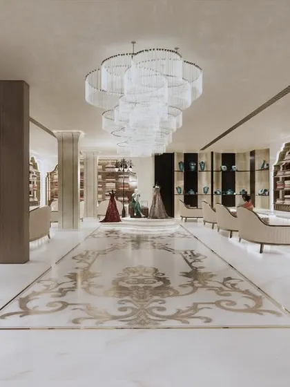 Looking down from the staircase, this view reveals the magnificent scale of the main floor. The intricate marble inlay on the floor acts as a central carpet, anchoring the space and guiding the customer's journey.