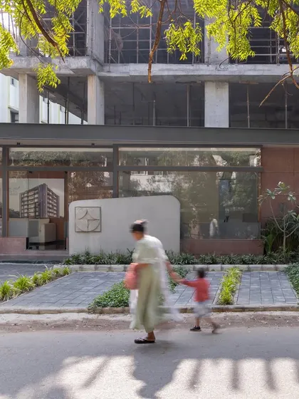 **Sanctum Site Office, Ahmedabad:** This image captures the site office as part of the streetscape, showing how it engages with the public realm. The design is approachable and transparent, inviting curiosity about the project taking shape.