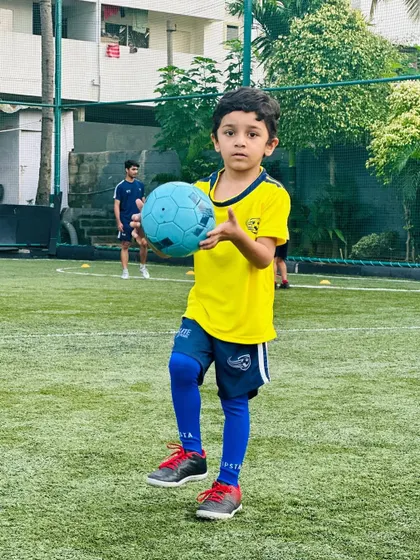 A young player holds his ball, ready for the next drill. Our players are always eager to learn and play.