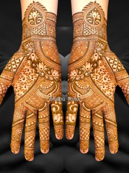 A beautiful symmetrical design with a heart-shaped cuff and intricate floral and geometric fillers.