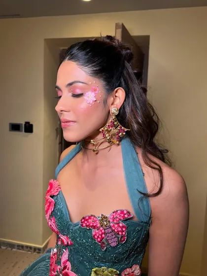 Eyes closed to showcase the pink and glitter eye makeup. This look is all about creativity and having fun with makeup.