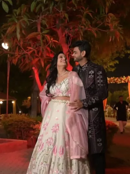 An evening function under the lights calls for an outfit that stands out. This couple chose a dark, intricately designed sherwani and a beautifully contrasting lehenga for their special moment.