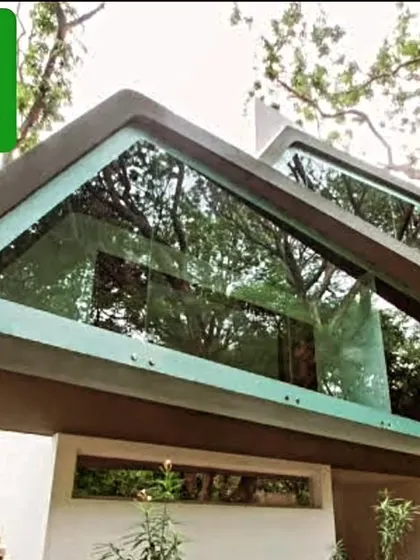 A detail of the Mobius Home's cantilevered glass structure. This element creates a feeling of being suspended amongst the trees, blurring the line between the interior and the lush exterior environment.