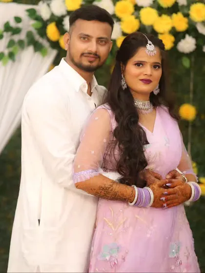 A classic couple portrait against a floral backdrop, perfect for an engagement or sangeet.