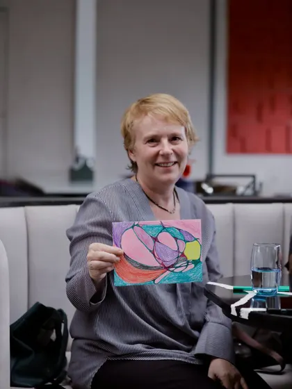 A proud artist with her work at our fundraiser. It's heartwarming to see people connect with their creativity while making a tangible difference for our animals.