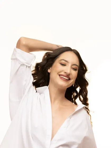 A simple white shirt, a genuine smile, and beautiful light. This portrait captures a moment of pure, effortless happiness and confidence, perfect for authentic personal branding.