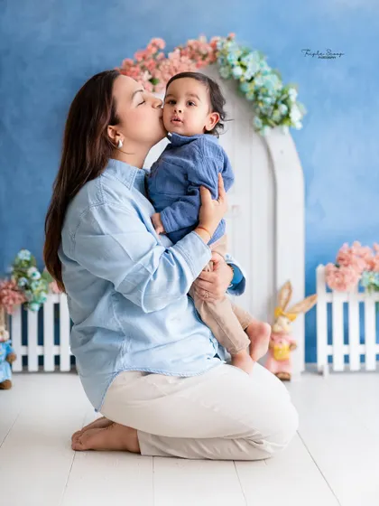 A mother gives her son a sweet kiss on the cheek. These tender moments are what make family photoshoots so precious.