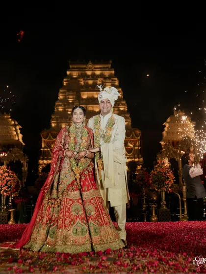 The couple stands before the magnificent temple structure, a moment of serene joy amidst the grandeur. The design provides a backdrop that is both monumental and deeply personal.