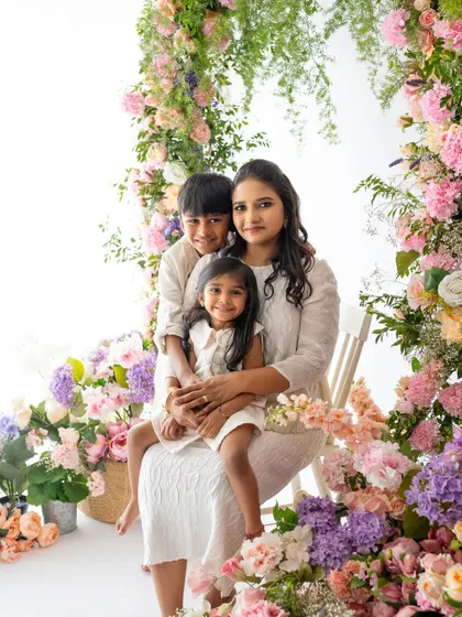 A mother with her son and daughter, all nestled together within the beautiful floral arch. A perfect portrait of a loving family.