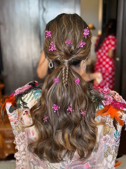 A complete view of this effortlessly chic low ponytail, showing how the flowers are scattered for a natural, garden-like effect.