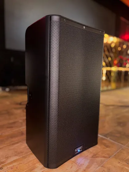 A close-up of a QSC K12.2 active loudspeaker, installed and ready to fill the room with powerful, clear sound. This is professional-grade equipment designed for live music and high-energy club environments.