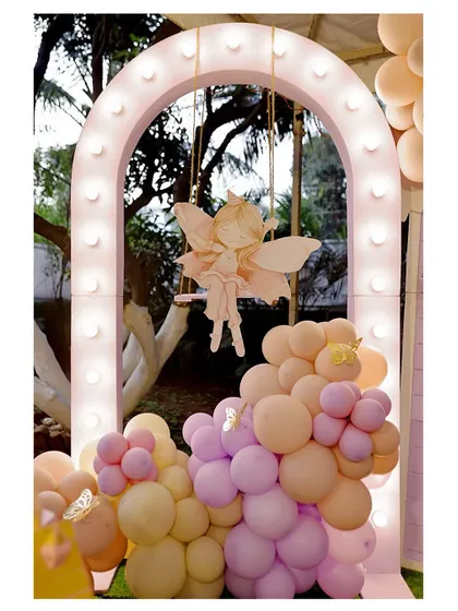 A whimsical fairy on a swing, framed by a light-up arch and a cascade of pastel balloons. This element adds a dynamic and magical touch to our enchanted party themes.