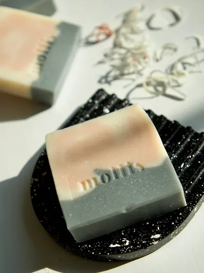 My Aqua soap, a handcrafted bar with a crisp, aquatic scent, resting on a black terrazzo-style soap dish.