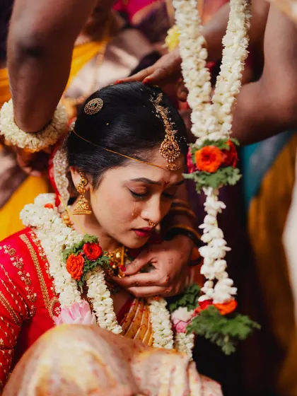 A poignant moment during the ceremony. The bride's makeup is subtle yet defining, with a focus on her eyes and a soft lip color that complements the traditional setting.