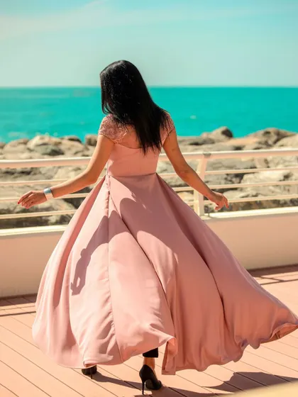 A joyful, candid-style shot of the model spinning in her flowing dress. This image feels spontaneous and full of life, perfect for capturing a brand's personality.