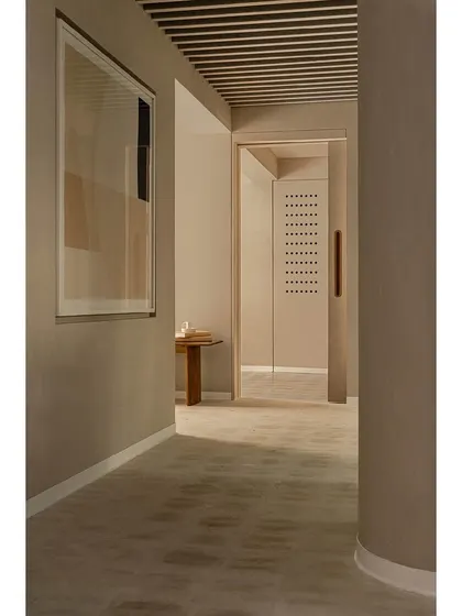 The corridor of the 'Crème' wellness center showcases our concept of 'restrained luxury'. We used a seamless, creamy wall finish, curved forms, and carefully placed lighting to create a fluid, calming journey for clients, transforming a simple passage into a sensory experience.
