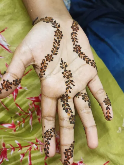 A delicate floral vine pattern that gracefully adorns the palm and fingers. This type of minimalist mehendi is perfect for someone trying henna for the first time or for young guests at a party.