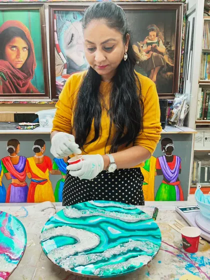 An instructor demonstrating the technique for creating a geode-inspired resin art piece. We provide expert guidance on layering colors and adding crystals for a realistic effect.