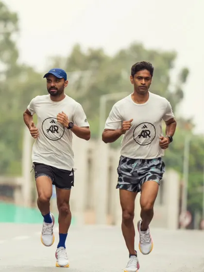 Two of our runners in sync during a training run, wearing our team gear with pride. We represent a community of dedicated athletes.