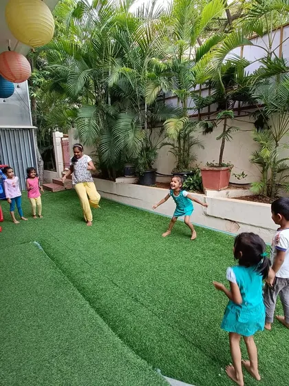 Kids enjoying a game of tag in our green, spacious outdoor area. We provide plenty of opportunities for unstructured play and running around.