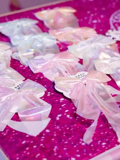 Beautiful, iridescent bows laid out as party favors for the Barbie-themed celebration.