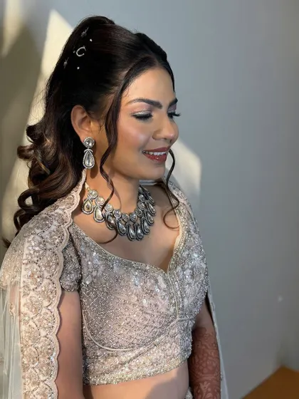 A happy, smiling bride, ready for her sangeet. The cool-toned silver jewellery pairs perfectly with her embellished lehenga.