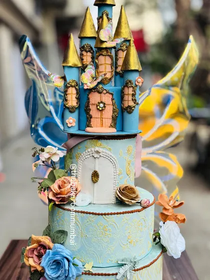 A fairytale brought to life. This multi-tiered princess castle cake features intricate, hand-sculpted details and kinetic butterfly wings that appear to flutter, creating a truly magical centerpiece for a grand celebration.