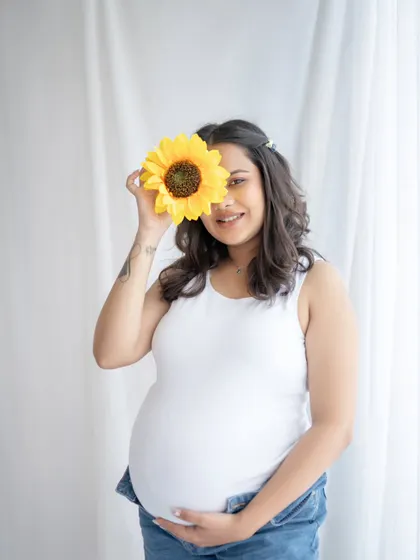A little bit of fun with a sunflower prop. This playful solo portrait is simple, sweet, and shows that maternity photos can be lighthearted and cheerful.